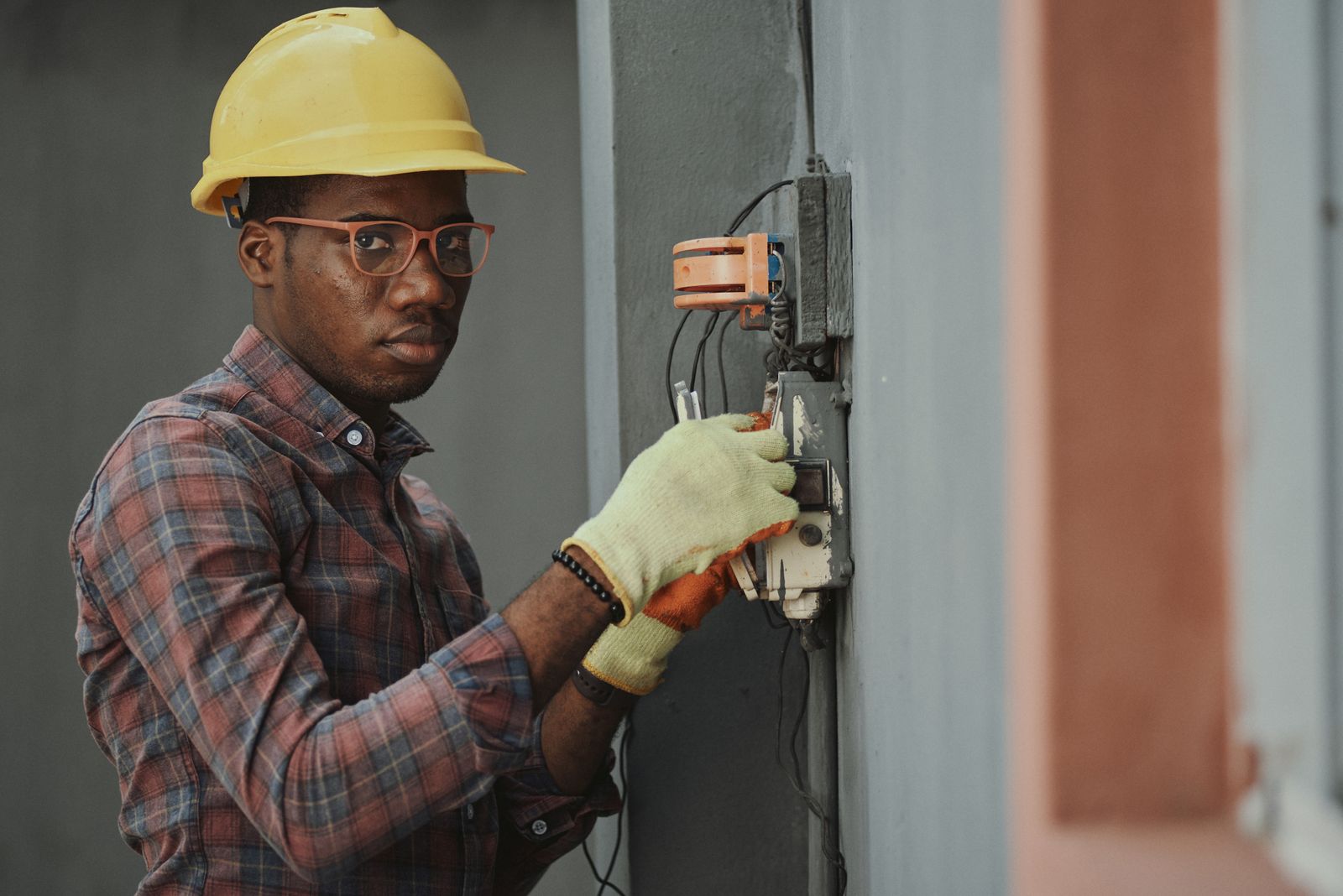 A handyman in a hard hat servicing an electrical box on a job in Southern Utah